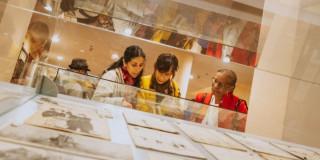 Imagen de tres mujeres observando una exposición