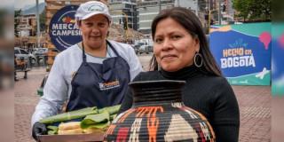 Foto de dos mujeres emprendedoras y víctimas del conflicto en una feria en Bogotá.