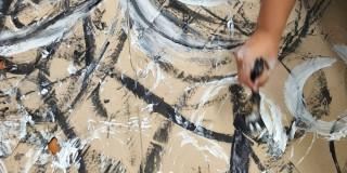Imagen de mano pintando trazos sobre papel