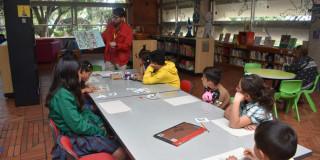 Foto que muestra niños y niñas sentados en una biblioteca