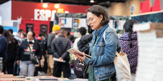 Imagen de una mujer observando un libro en la FILBo 2026.