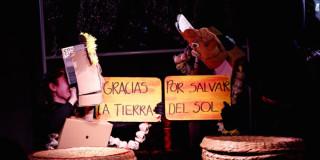 Imagen de dos títeres en cartón con carteles