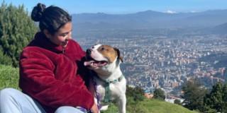 Foto de una mujer junto a su perro en una caminata en Bogotá.