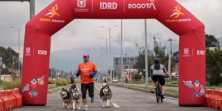 bogotano hace ejercicio con perros en Ciclovía de Bogotá