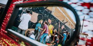 Imagen de personas pintando un mural en la esquina redonda del BDC