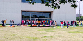 Foto que muestra un grupo de personas reunidas en un parque haciendo ejercicios de respiración