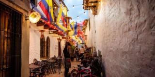 Imagen de calle del Centro de Bogotá con banderas de Colombia
