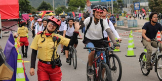 Personas en bicicleta durante Ciclovía en Bogotá acompañadas por Guardianes de la Ciclovía