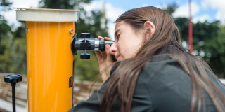 Imagen de niña mirando a través de un telescopio 
