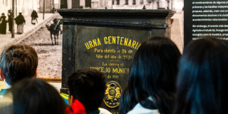 Imagen de Urna centenaria con personas observándola 