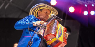 Imagen de uno de los artistas que estará en Vallenato mientras toca un acordeón.