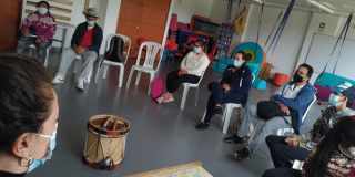 Imagen de varios adultos mayores tomando el taller, en el centro se observa un tambor.