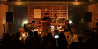 Imagen de la agrupación dando un concierto con sus instrumentos musicales.
