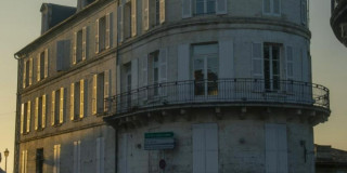 Imagen de la fachada de un edificio antiguo pintado de blanco.