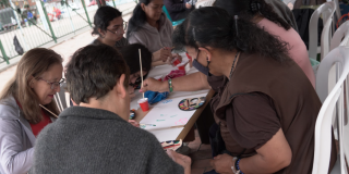 Imagen de un grupo de personas pintando sobre una mesa