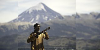 Imagen de Facundo Salgado tocando guitarra con un fondo de la cordillera de los Andes