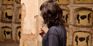 Imagen de mujer de espaldas con fondo de Columbarios del Cementerio Central