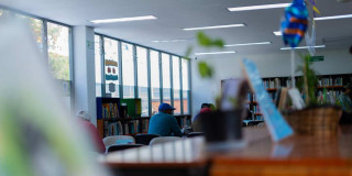 Foto que muestra personas en una biblioteca 
