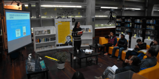 Personas escuchando una conferencia en una biblioteca.
