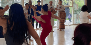 Imagen de varias mujeres tomando clase de capoeira en Cefe Chapinero, al fondo se ve un conjunto con instrumentos musicales.