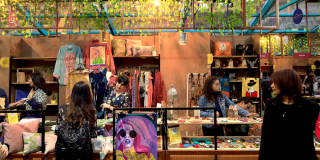 Imagen de varias estand de la Feria de Emprendedores donde hay personas comprando y mirando en una feria de emprendimientos en Bogotá.