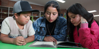 Imagen de 3 niños usuarios de las Bibliotecas Públicas de Bogotá leyendo un libro