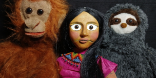 Imagen de una muñeca de títeres con un mono y un oso de peluche
