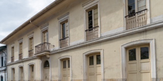 Imagen de la fachada de una casa antigua de color beige, que corresponde a la Casa Fernández.