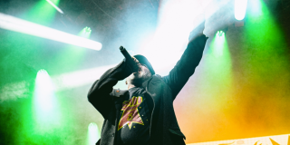 Imagen de un hombre en tarima cantando.
