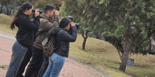 Imagen de personas con binoculares en bosque urbano de Bogotá