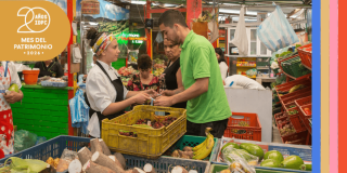 Imagen de una mujer entrgando una bolsa de compra a uh hombre en Plaza de mercado