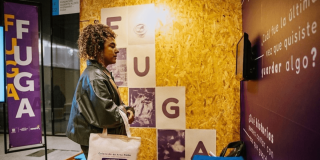 Imagen de stand de la Fuga con una mujer mirando la pantalla en ARTBo 