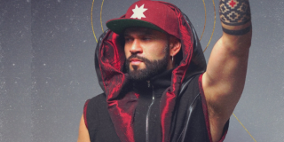 Imagen d eun hombre que viste chaleco y gorra negro con rojo.