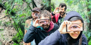 Imagen de cuatro (4) hombres que tienen un celular en la mano proyectando sus ojos.