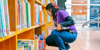 Imagen de funcionaria organizando catálogo de libros en BibloRed Bogotá.