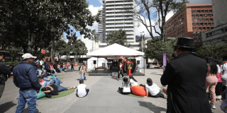 Imagen de carpa de la FUGA en espacio público con personas alrededor