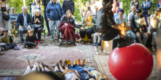 Imagen de varias personas disfrutando de la actividad, hay varios niños acostados en fila.
