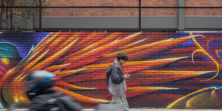 Imagen de un hombre que recorre a pie un mural.