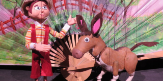 Imaggen de las dos marionetas protagonistas de la obra: un burro café y un hombre.