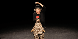 Foto de un hombre con un títere en una obra de teatro en Bogotá.