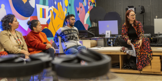 Imagen de varias personas en un estudio donde hay varios computadores.