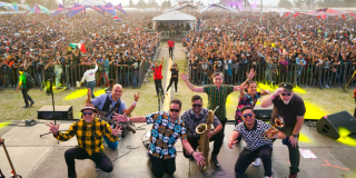 Imagen de la banda Desorden Público en la tarima de Rock al Parque, de fondo se ven muchas personas asistentes.