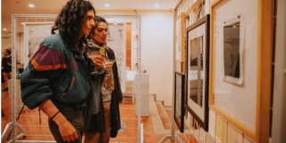 Imagen de 2 personas mirando colección de arte en la FUGA