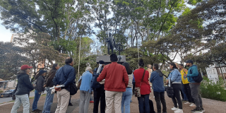 Imagen de personas alrededor de una estatua en espacio público