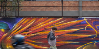 Imagen de un hombre que recorre a pie un mural.