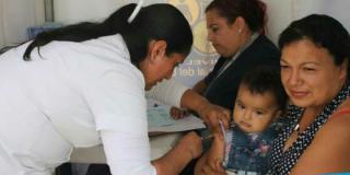Una profesional de la salud aplica una vacuna a un niño pequeño.