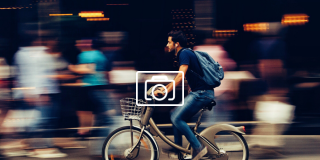 Un ciudadano monta su bici en una gran ciudad.