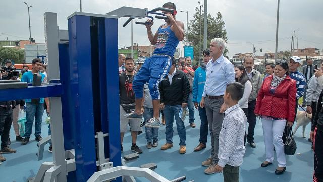 El Alcalde Enrique Peñalosa observa a un señor hacer ejercicio en una de las maquinas del nuevo parque de Bosa
