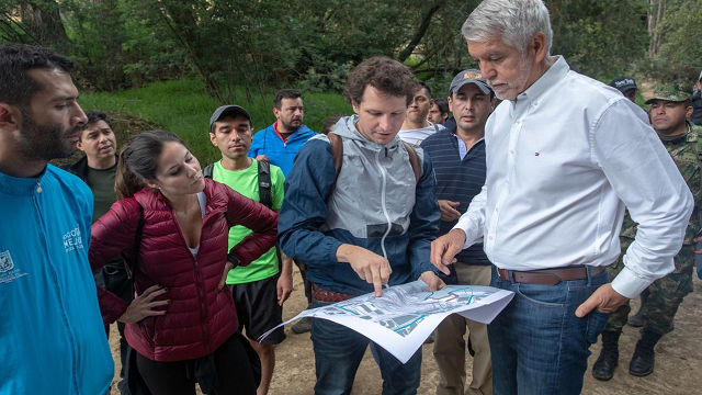 El Alcalde Enrique Peñalosa acompañado de varias personas caminando por el Parque San Rafael, observan un mapa 