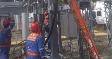 Imagen de tecnicos de Enel que revisan los cables de energía de un poste.